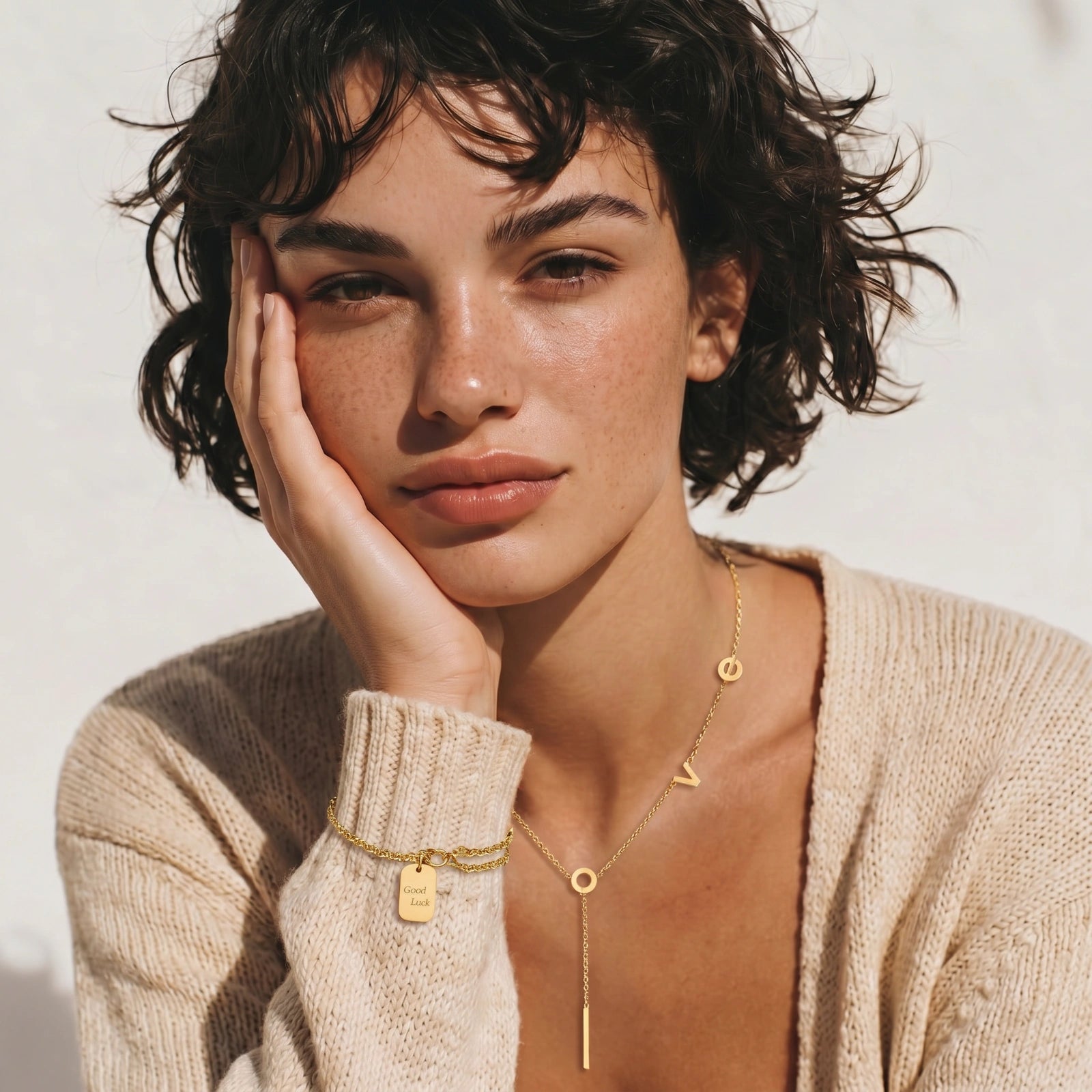 Woman wearing gold jewelry with a neutral background